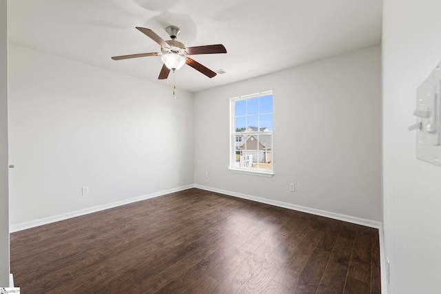 unfurnished room with dark wood-style flooring, visible vents, ceiling fan, and baseboards