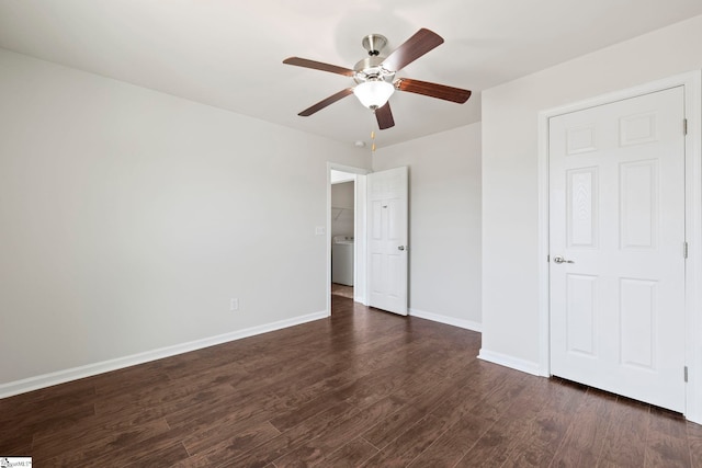 unfurnished bedroom with dark wood-type flooring, baseboards, a ceiling fan, and washer / clothes dryer
