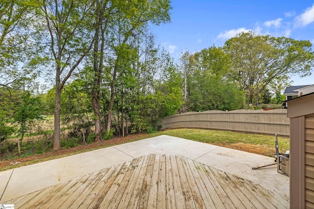 wooden deck featuring fence and a patio