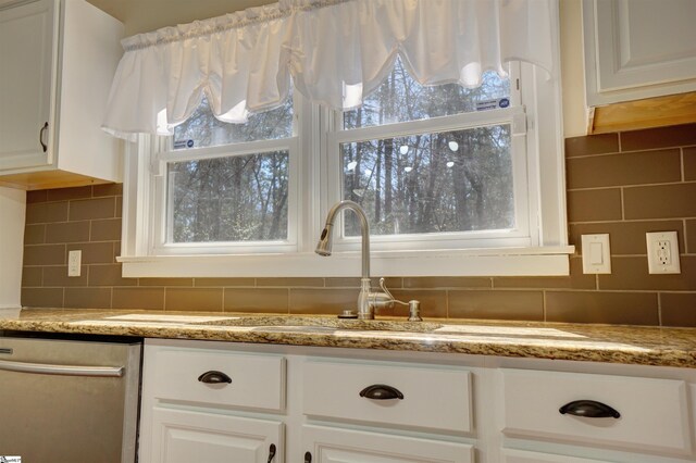 kitchen with white cabinetry, backsplash, a healthy amount of sunlight, and stainless steel dishwasher