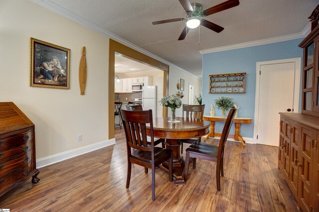 dining space with dark wood finished floors, a textured ceiling, crown molding, and ceiling fan