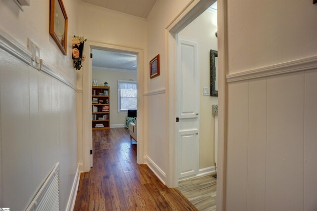 corridor featuring visible vents, wood finished floors, and crown molding