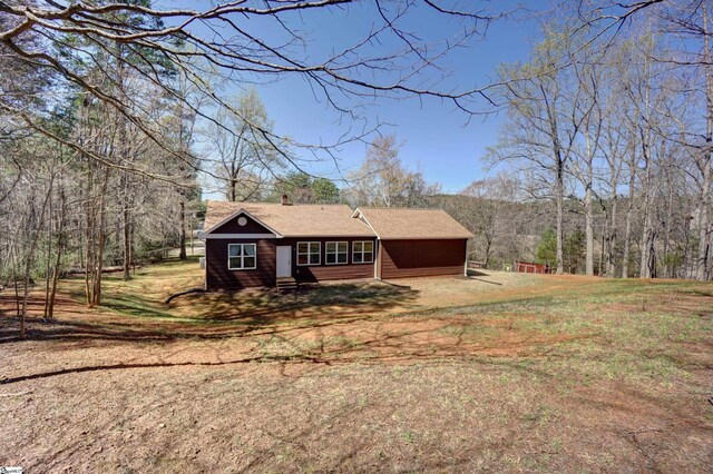view of front facade with a wooded view and entry steps