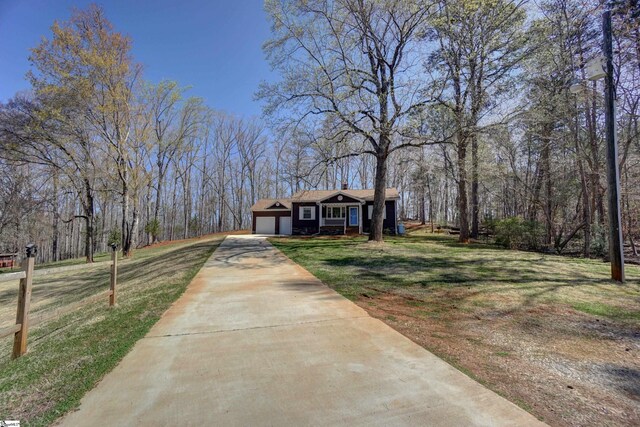 view of front of home featuring a front lawn, driveway, and a garage