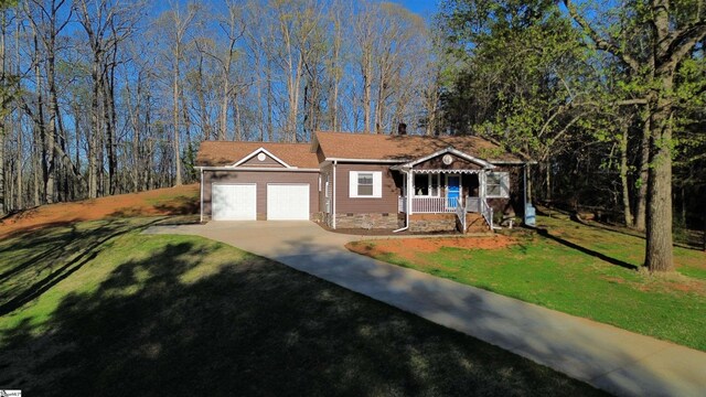 view of front facade featuring driveway, an attached garage, a front lawn, crawl space, and a porch