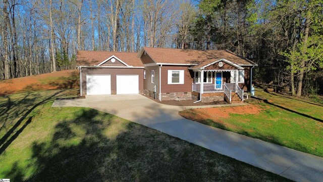 view of front of home featuring driveway, a front yard, a porch, and a garage
