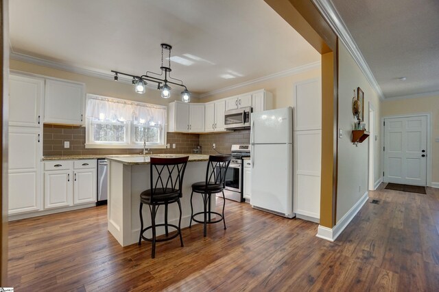 kitchen with dark wood finished floors, white cabinets, a breakfast bar, and stainless steel appliances