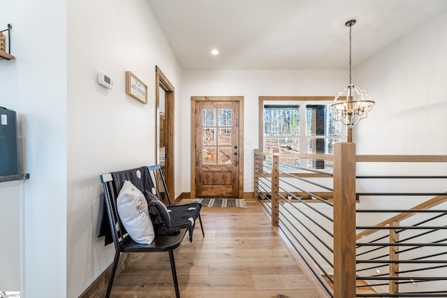 interior space with baseboards, light wood-style flooring, recessed lighting, and a notable chandelier