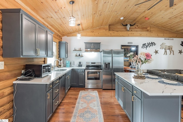 kitchen featuring a center island, under cabinet range hood, a sink, light wood-style floors, and appliances with stainless steel finishes