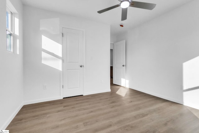 unfurnished bedroom featuring baseboards, light wood-style flooring, and ceiling fan