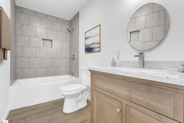bathroom with vanity, toilet, wood finished floors, and tub / shower combination