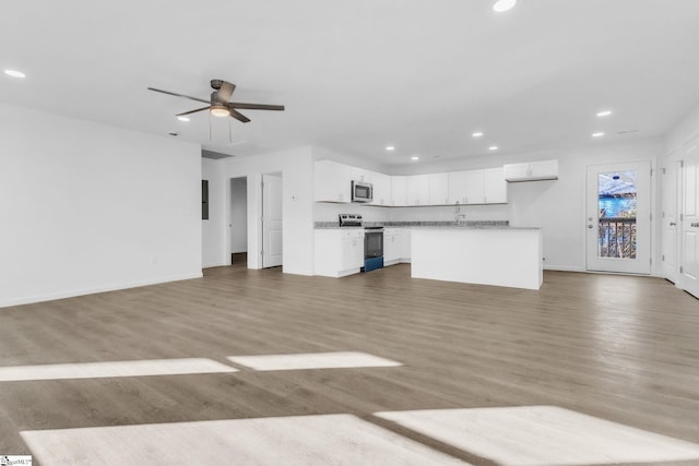 unfurnished living room featuring baseboards, recessed lighting, ceiling fan, and wood finished floors