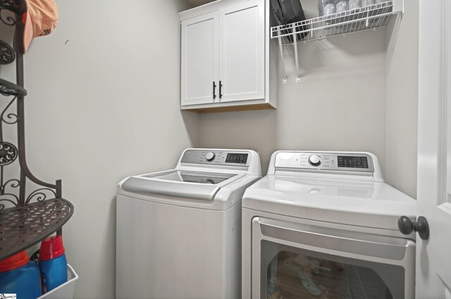 laundry area with separate washer and dryer and cabinet space