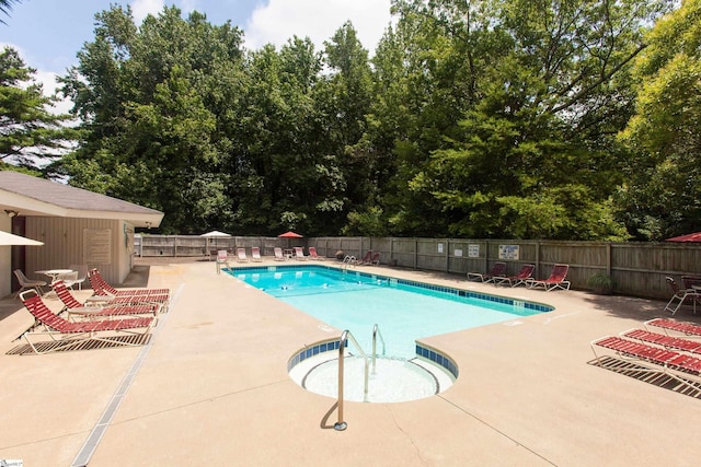 community pool featuring fence and a patio