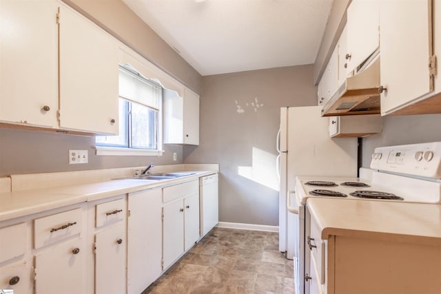 kitchen featuring under cabinet range hood, light countertops, a sink, and white appliances