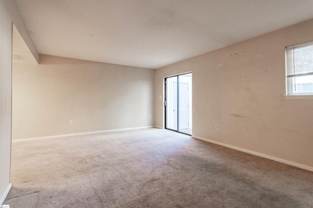 carpeted spare room with baseboards and a textured ceiling