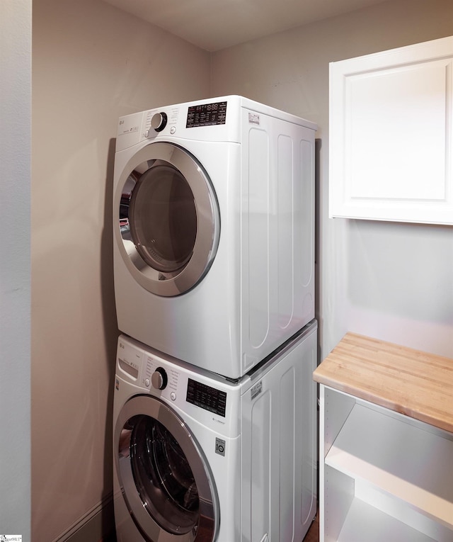 laundry area with stacked washer and dryer and laundry area