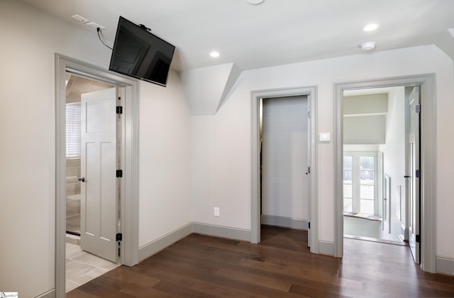 unfurnished bedroom featuring baseboards, ensuite bath, wood finished floors, and recessed lighting