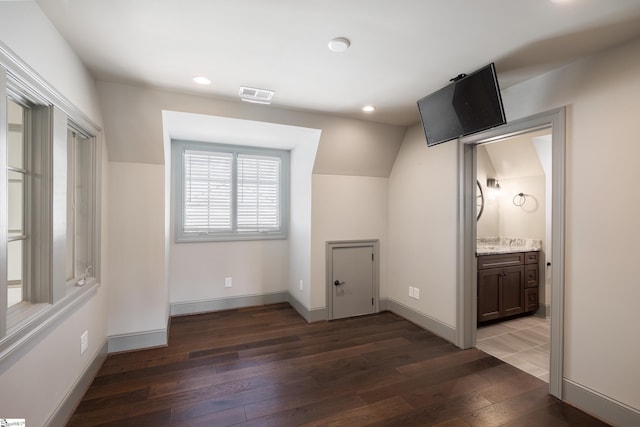 unfurnished bedroom with wood-type flooring, lofted ceiling, baseboards, visible vents, and recessed lighting