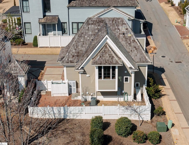 view of front of house with a shingled roof and fence