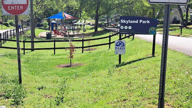 view of home's community with a yard, playground community, and fence