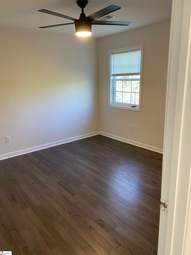 spare room featuring dark wood-type flooring, baseboards, and ceiling fan
