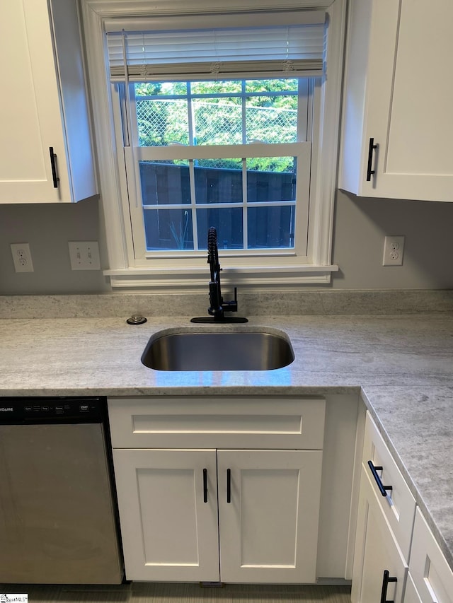 kitchen featuring white cabinetry, a sink, a healthy amount of sunlight, and dishwasher