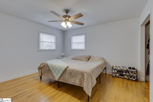 bedroom featuring light wood finished floors, baseboards, and ceiling fan