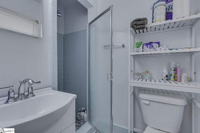 bathroom with toilet, a sink, and a stall shower