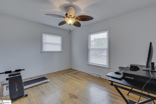 workout area featuring baseboards, visible vents, ceiling fan, and hardwood / wood-style floors