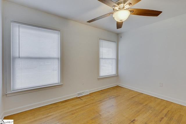 empty room with a ceiling fan, baseboards, light wood-style floors, and visible vents