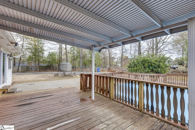 wooden terrace with a fenced backyard, an outbuilding, and a shed