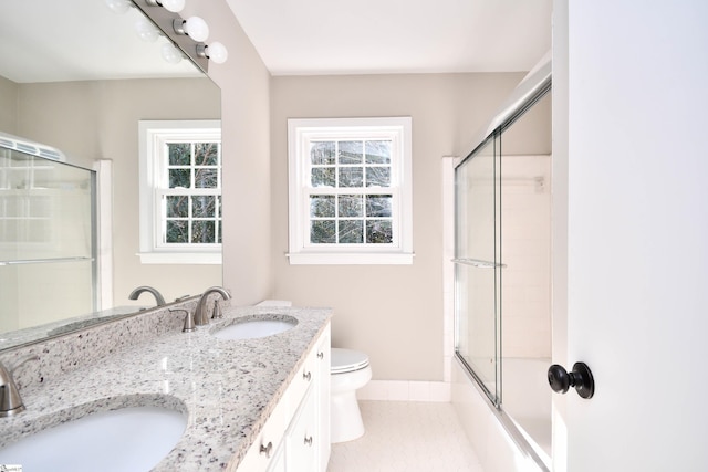 full bath with double vanity, a sink, tile patterned floors, and toilet
