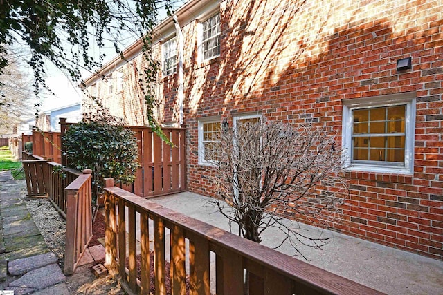 view of side of home with brick siding and fence