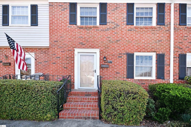 property entrance featuring brick siding