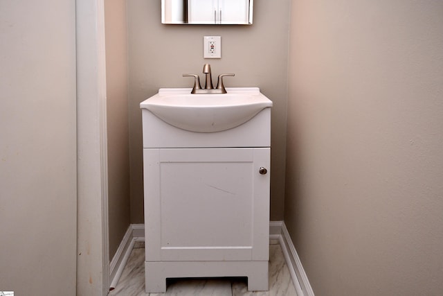 bathroom featuring baseboards, marble finish floor, and vanity