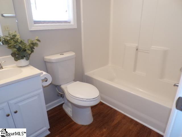 full bathroom with wood finished floors, toilet, and vanity
