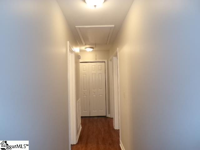 hall with attic access, baseboards, and dark wood finished floors