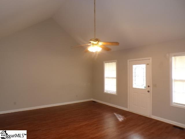 entryway with wood finished floors, baseboards, vaulted ceiling, and ceiling fan