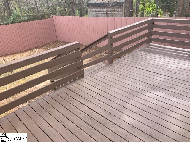 wooden terrace with a fenced backyard