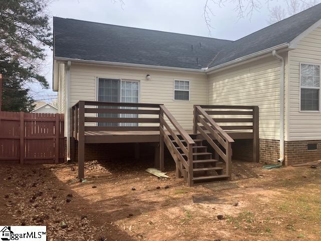 back of property featuring a shingled roof, fence, a wooden deck, and stairway