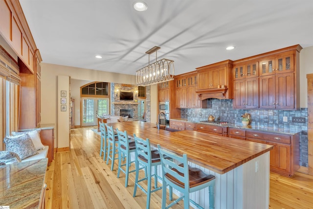 511 Palmer Way, Sunset, SC 29685 - kitchen featuring butcher block countertops, a sink, light wood-style floors, open floor plan, and backsplash