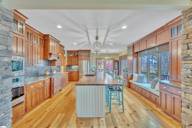 511 Palmer Way, Sunset, SC 29685 - kitchen featuring brown cabinetry, tasteful backsplash, light wood finished floors, and appliances with stainless steel finishes