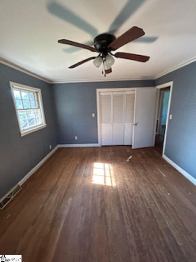 unfurnished bedroom with baseboards, visible vents, crown molding, and wood finished floors