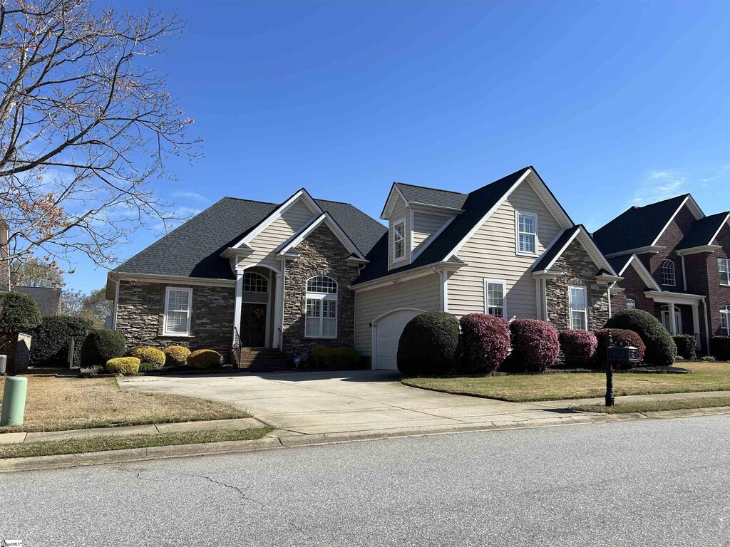 view of front of home featuring driveway and stone siding