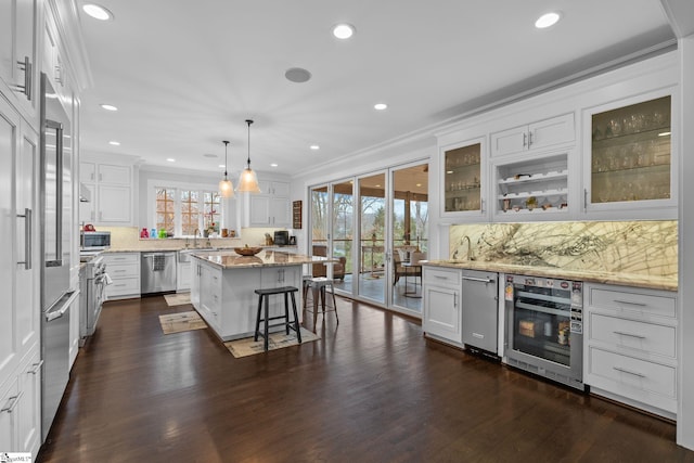 kitchen with white cabinetry, ornamental molding, dark wood-style floors, dishwasher, and light stone countertops