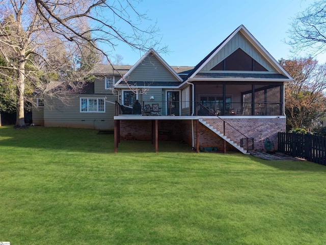 rear view of house featuring a lawn, a sunroom, fence, and stairway
