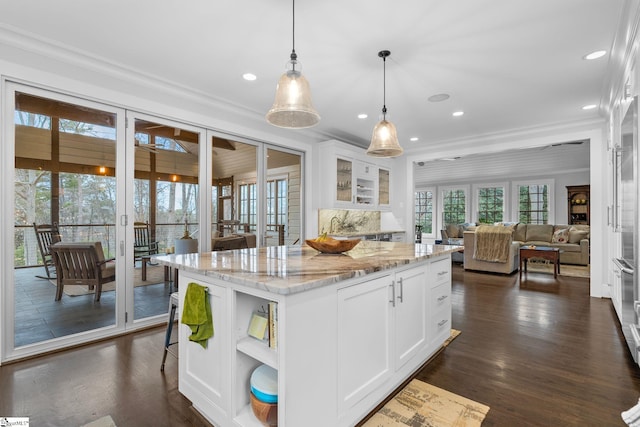 kitchen featuring dark wood-style flooring, light stone countertops, ornamental molding, and open shelves