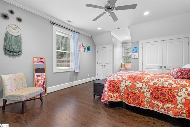 bedroom with crown molding, dark wood-style flooring, baseboards, multiple closets, and visible vents