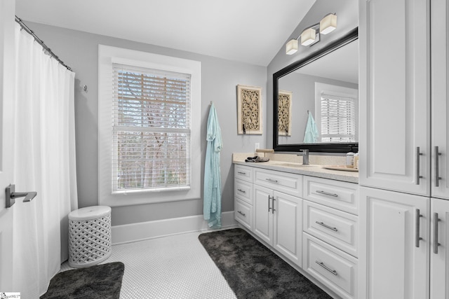 full bathroom with baseboards, lofted ceiling, curtained shower, and vanity